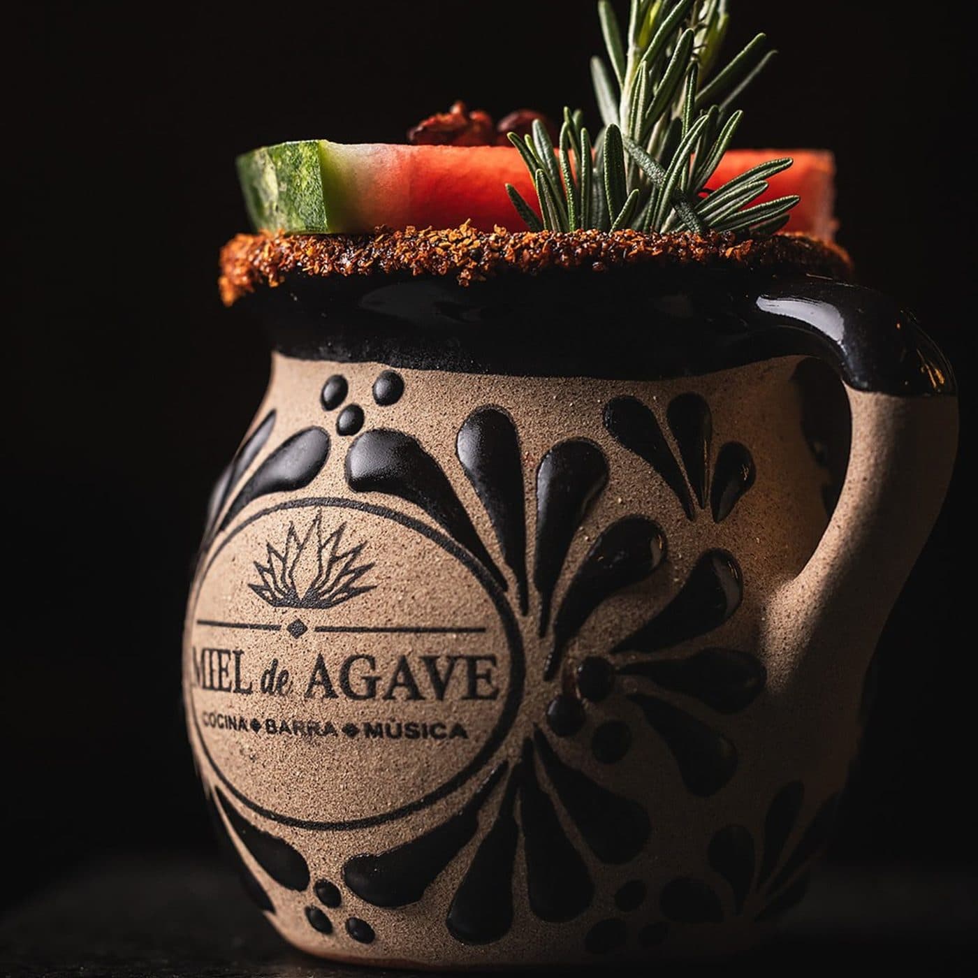 A Miel de Agave cocktail served in a branded clay mug