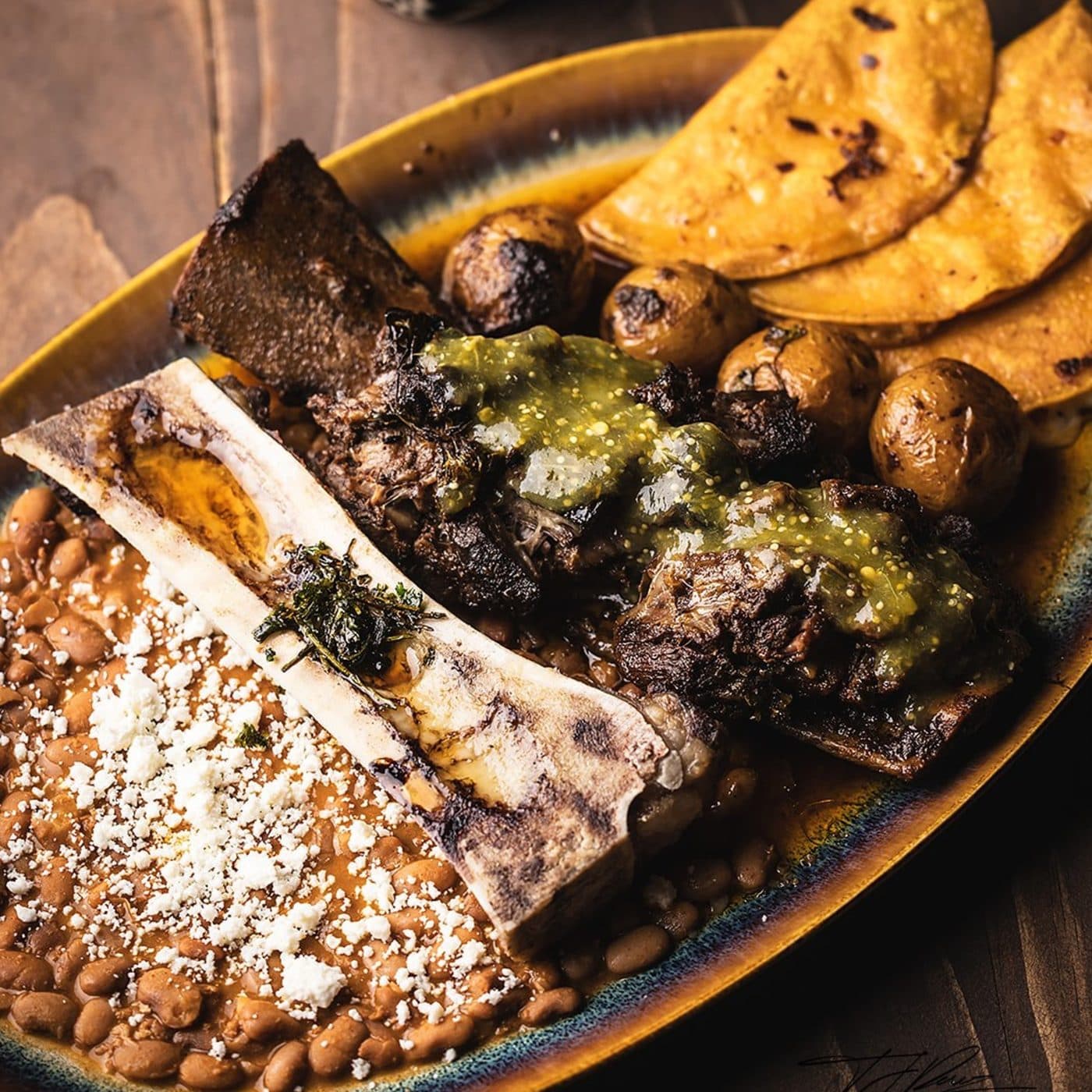 Miel de Agave short rib birria with bone marrow, beans, potatoes, and quesadillas