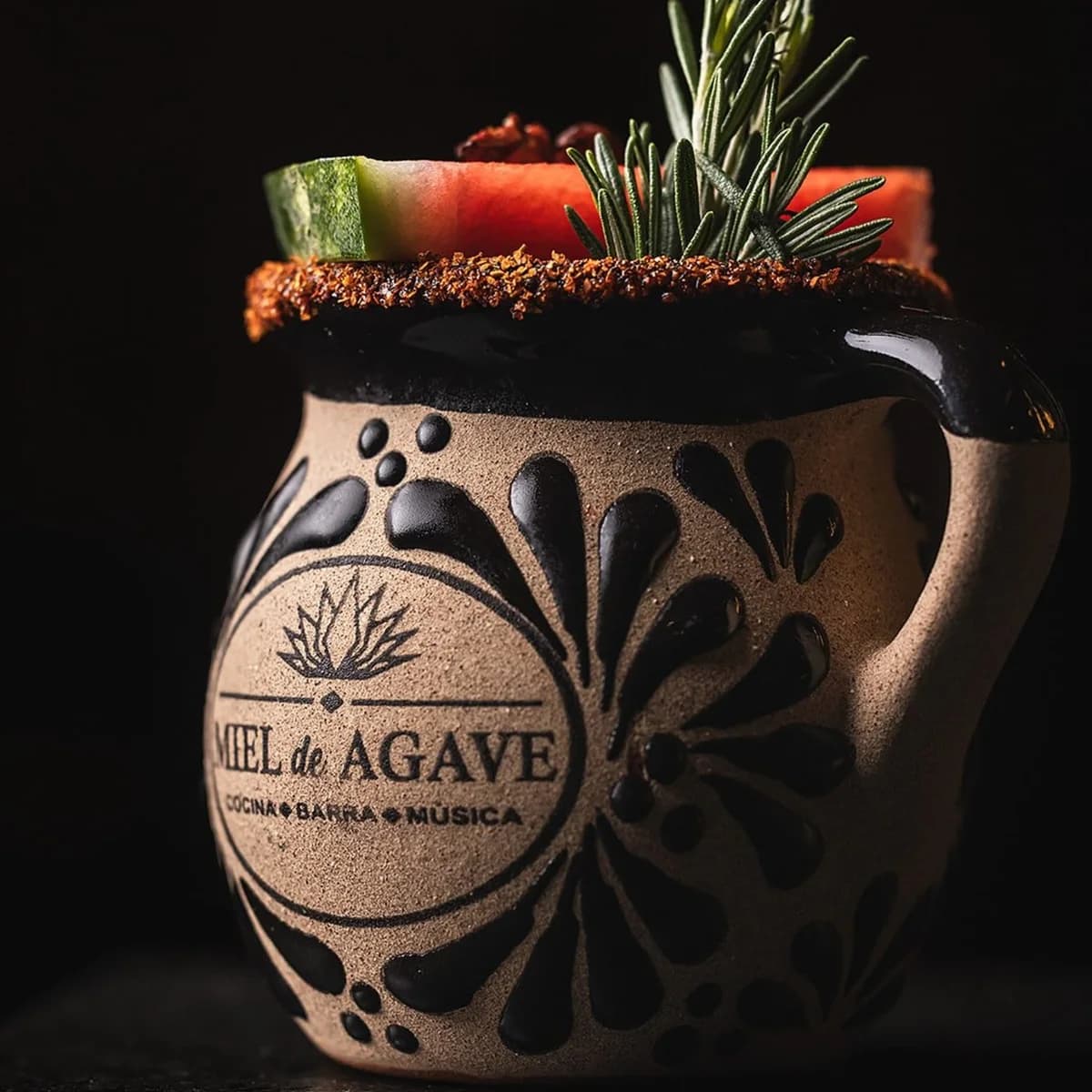 A signature Miel de Agave cocktail in a branded clay mug