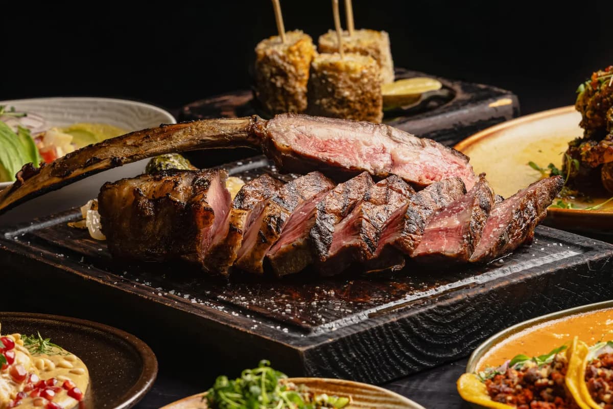 Sliced steak with sides at Origen Gilbert